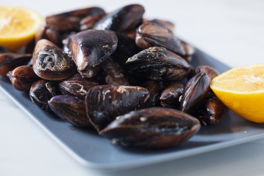 Close up of a plate with freshly coocked mussels on dining table. High quality photo