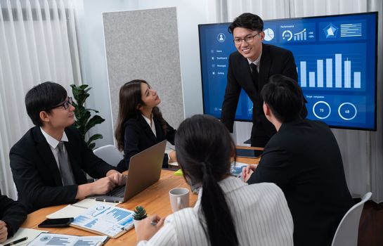 Confidence and asian businessman give presentation on financial analyzed by business intelligence in dashboard report to other people in board room meeting to promote harmony in workplace.