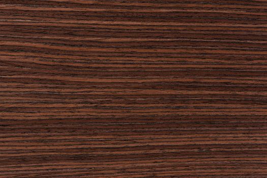 Rosewood texture. Texture of dark mahogany with an intense pattern, natural rosewood veneer for the production of furniture or yacht decoration.