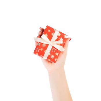 Woman hands give wrapped Christmas or other holiday handmade present in red paper with Gold ribbon. Isolated on white background, top view. thanksgiving Gift box concept.