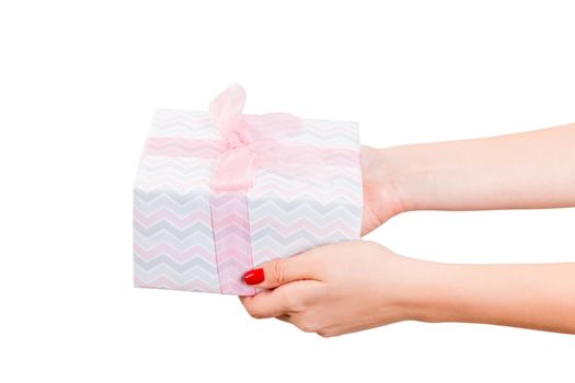 Woman hands give wrapped Christmas or other holiday handmade present in colored paper with pink ribbon. Isolated on white background, top view. thanksgiving Gift box concept.