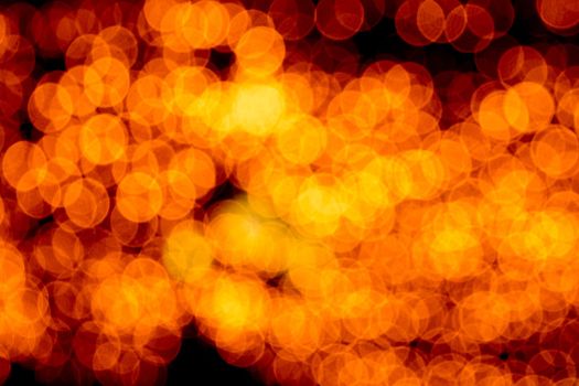 Unfocused abstract orange bokeh on black background. defocused and blurred many round light.