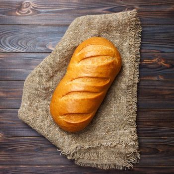 loaf of bread on wooden background, food closeup.