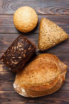 Bakery background, bread assortment on black wooden backdrop. Top view with copy space.