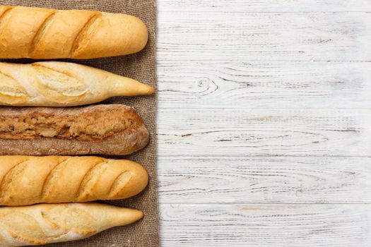 Assortment of fresh French baguettes on a wooden table.