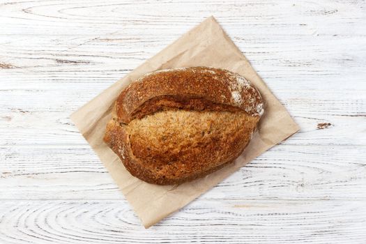 Loaf of bread on a grocey paper bag in european style. top view.