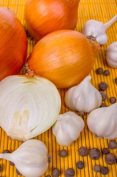 Garlic and onion, pepper on wooden board.