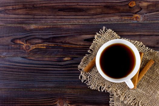 Coffee cup on wooden table texture. View from above.