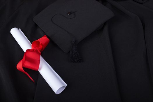 Graduation Day. A gown, graduation cap, and diploma and laid out ready for graduation day.