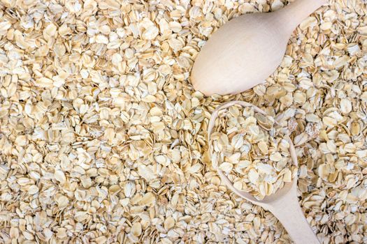 Oatmeal with a wooden spoon background, oat flakes background