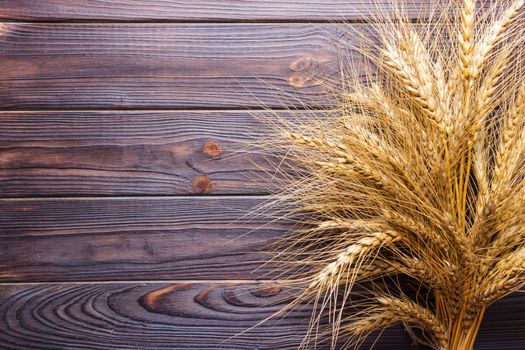 Wheat stems, on wooden background Harvest concept