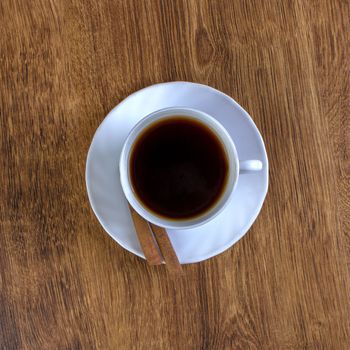 coffee cup, cinnamon sticks, wooden table background