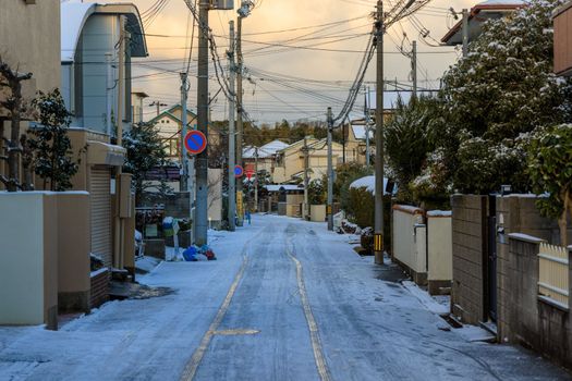 Tire tracks in light snow on street in quiet residential neighborhood at dawn. High quality photo