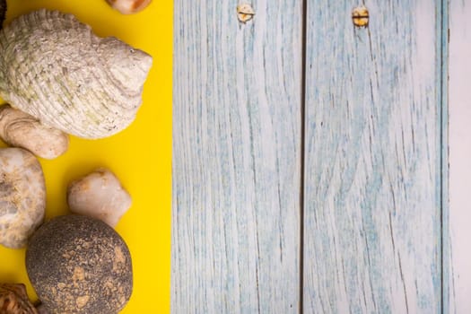stones and shells on a blue wooden background and a yellow background.Marine theme.