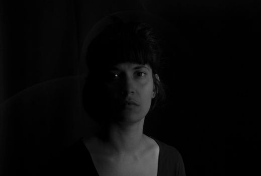 Dramatic portrait of an indian girl on black background