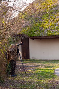 Bird photographer wearing camouflage cape take photos with a camera and telephoto, Laguna di Marano