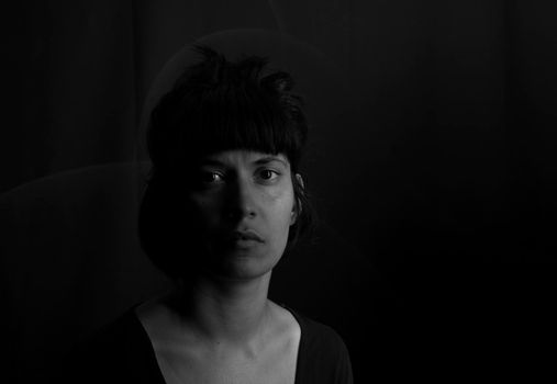 Dramatic portrait of an indian girl on black background