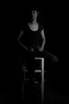 Black and white portrait of a girl sitting on a stool