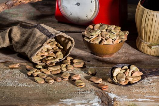 Composition with dried broad beans in a wooden table