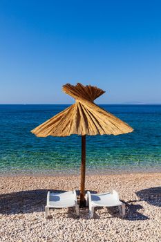 Straw umbrella in the beautiful Oprna beach in the Krk island, Croatia