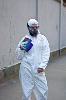 Young woman wearing protective white jumpsuit handing out information brochures in the empty street