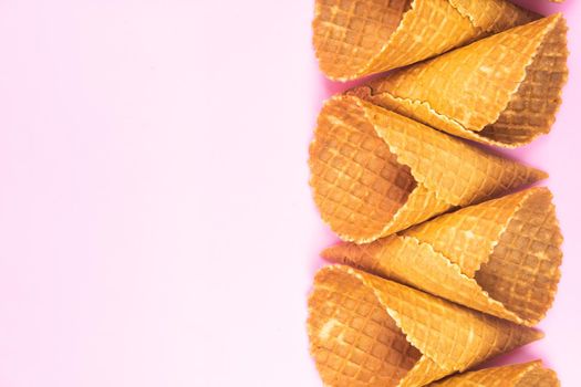 figures from waffle cones for ice cream on a pink background.