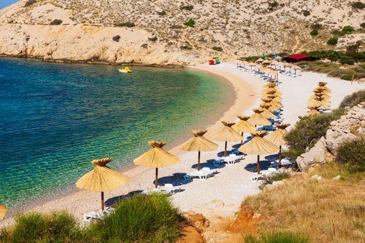 Straw umbrellas in the beautiful Oprna beach in the Krk island, Croatia