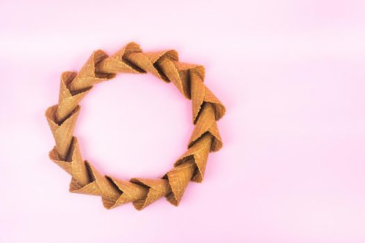 smooth circle of waffle cones for ice cream on a pink background.