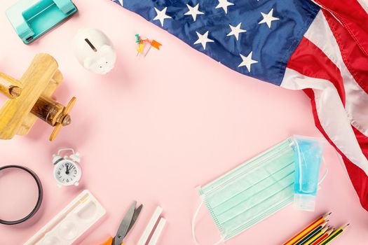 Back to school or college concept. Top view of school supplies stationery, American flag and surgical face mask, isolated on pink background, Back to education new normal during outbreak coronavirus