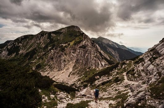 Young woman with backpack hiking along the path in the scenic Vogel mountain part of southern Julian Alps and Triglav National Park heritage of Slovenia