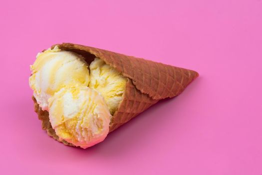 Fruit-scented ice cream balls in a waffle cone on a pink background