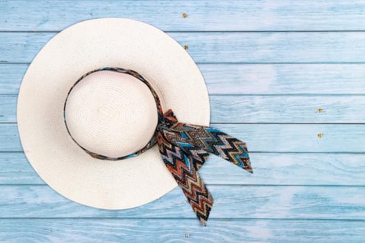 Top view of a straw white hat lying on a blue wooden background.The concept of summer holidays.