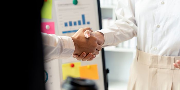 Business handshake for teamwork of business merger and acquisition,successful negotiate,hand shake,two businessman shake hand with partner to celebration partnership and business deal concept.