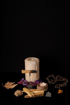 zen image of smoking palo santo,, holy stick with candles and japa-mala on black background