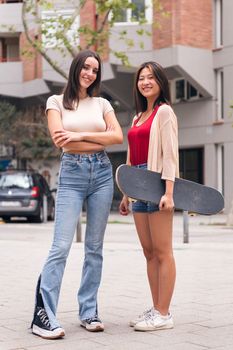 vertical photo of two young women posing happy and smiling looking at camera, concept of female friendship and teenager lifestyle