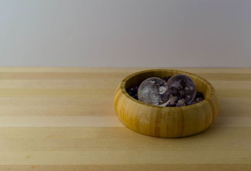 Crystal balls with amethyst stones on a wooden table.