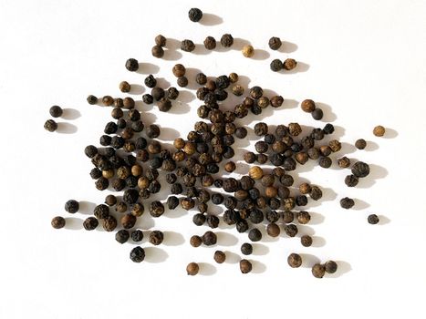 Texture, background. Black peppercorns on a white background, seasoning.