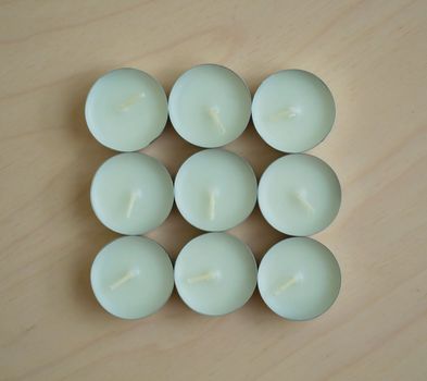 White candles. White candles on a wooden table close-up.