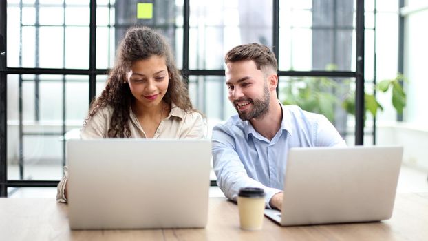 Group of business people working together on a business project in the office behind a laptop