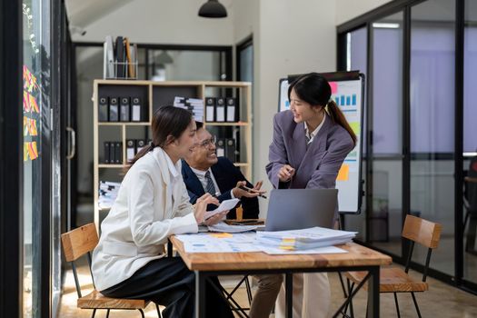 Group of young business people working and communicating while sitting at the office desk together with colleagues. Project and Business concept