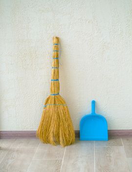 House cleaning. In the photo there is a broom and a blue dustpan.