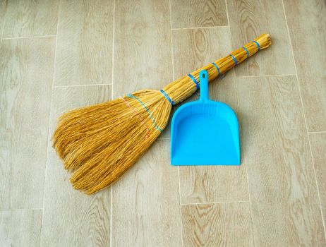 House cleaning. In the photo there is a broom and a blue dustpan.