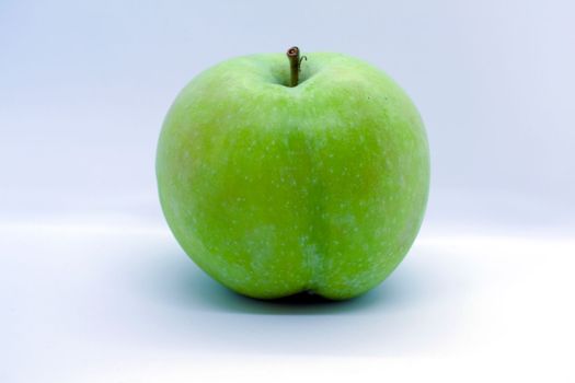 Green apple on a white background close-up.