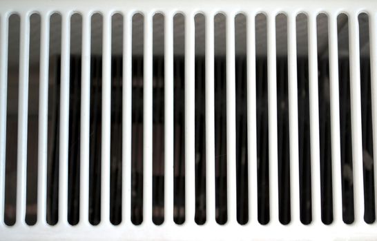 White metal grate. Photo of a white grate on a radiator.