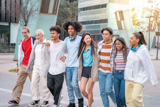 Photo of Cheerful group of happy best friends walking smiling hugging each other. Three couple having fun together outdoors at park in the city. People enjoying travel in vacation holidays.