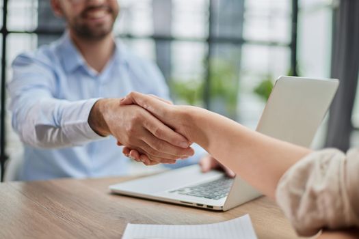 Young business people shake hands in the office. End of a successful meeting. two people