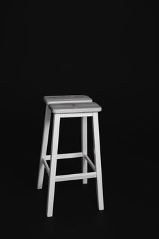minimalistic wooden chair against black background. Concept modern interior and design furniture in room. High stool in loft style. Retro Bar chair. Vintage wooden metal chair