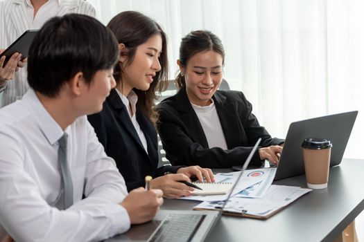 Harmony in office concept as business people analyzing dashboard paper together in workplace. Young colleagues give ideas at manager desk for discussion or strategy planning about project.