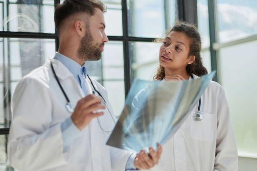 Concentrated male doctor looking at x-ray picture of spine