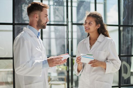 pharmacist checks the dose of the drug with his colleague